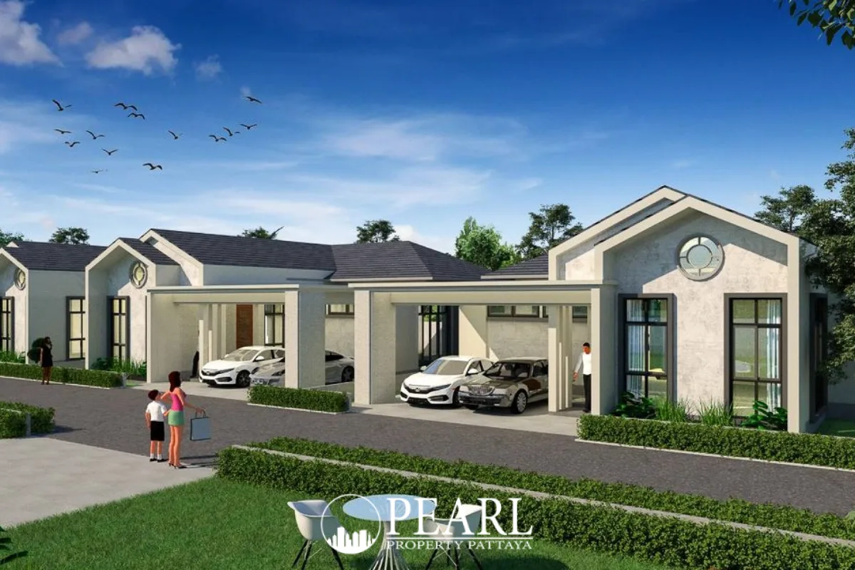 The Hamlet Pattaya, exterior view of modern houses with carports, green lawns, and a street under a blue sky.