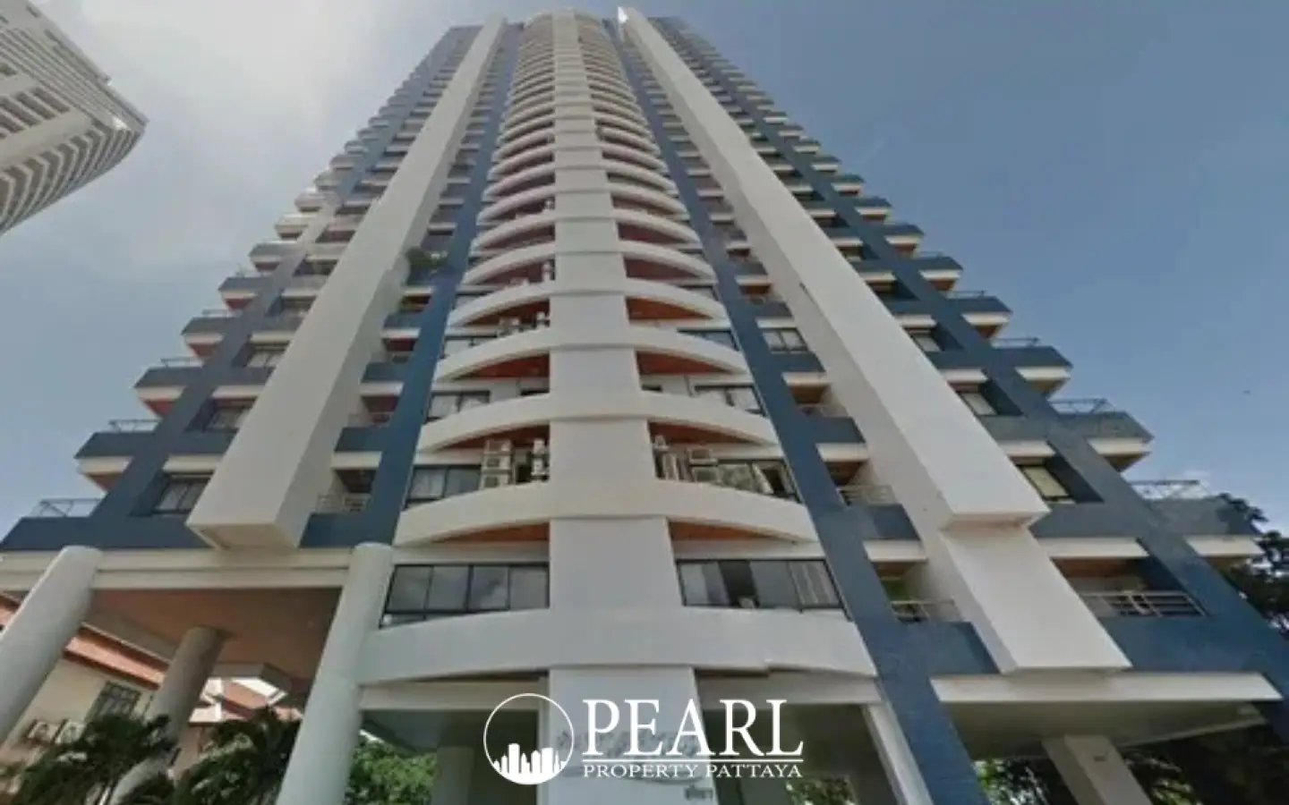 Baan Haad Uthong Condominium tall building exterior, upward view from ground level against a blue sky.
