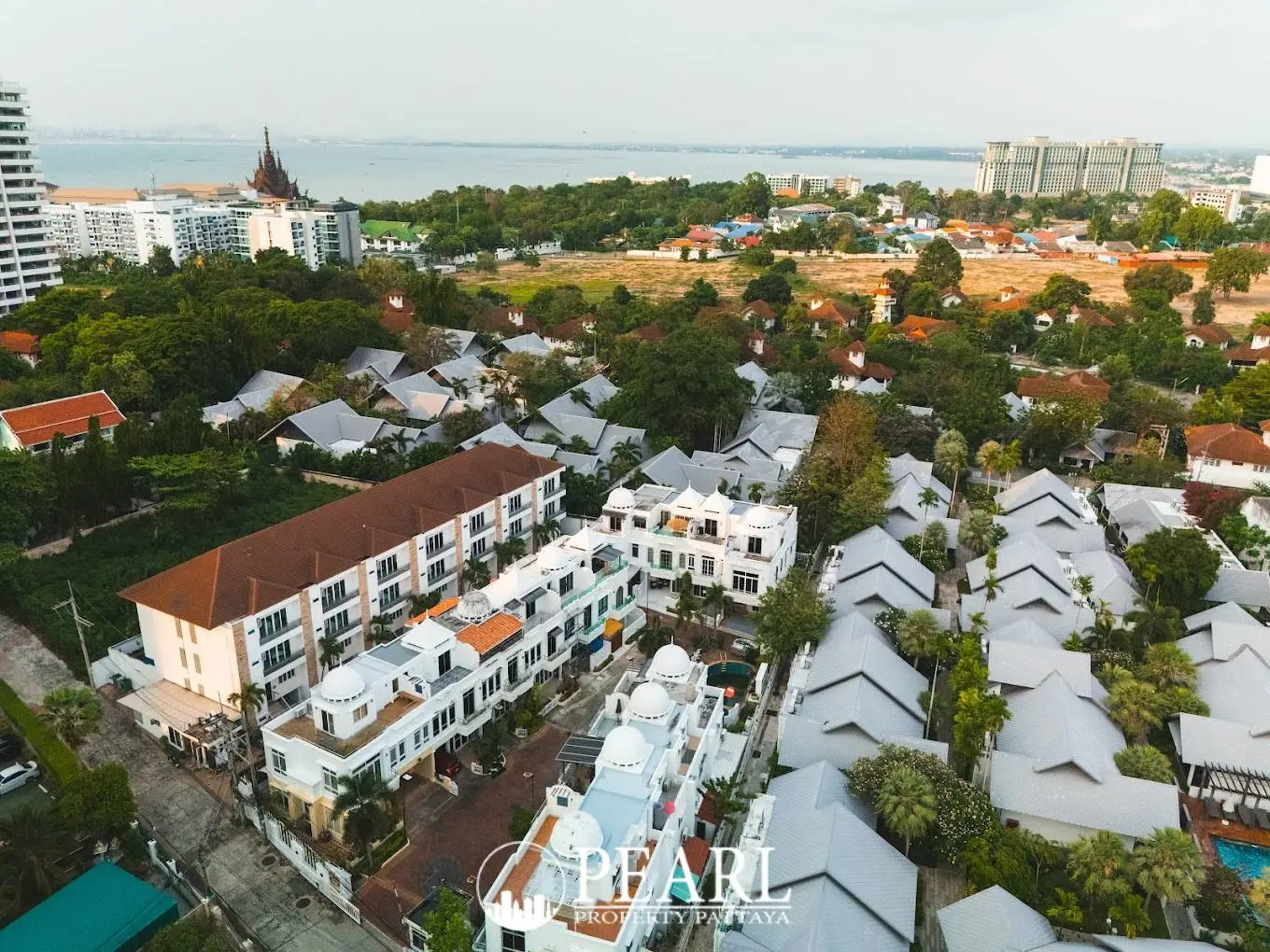 Wongamat Exclusive Place aerial view of multiple white townhouses with domed roofs and surrounding neighborhood.
