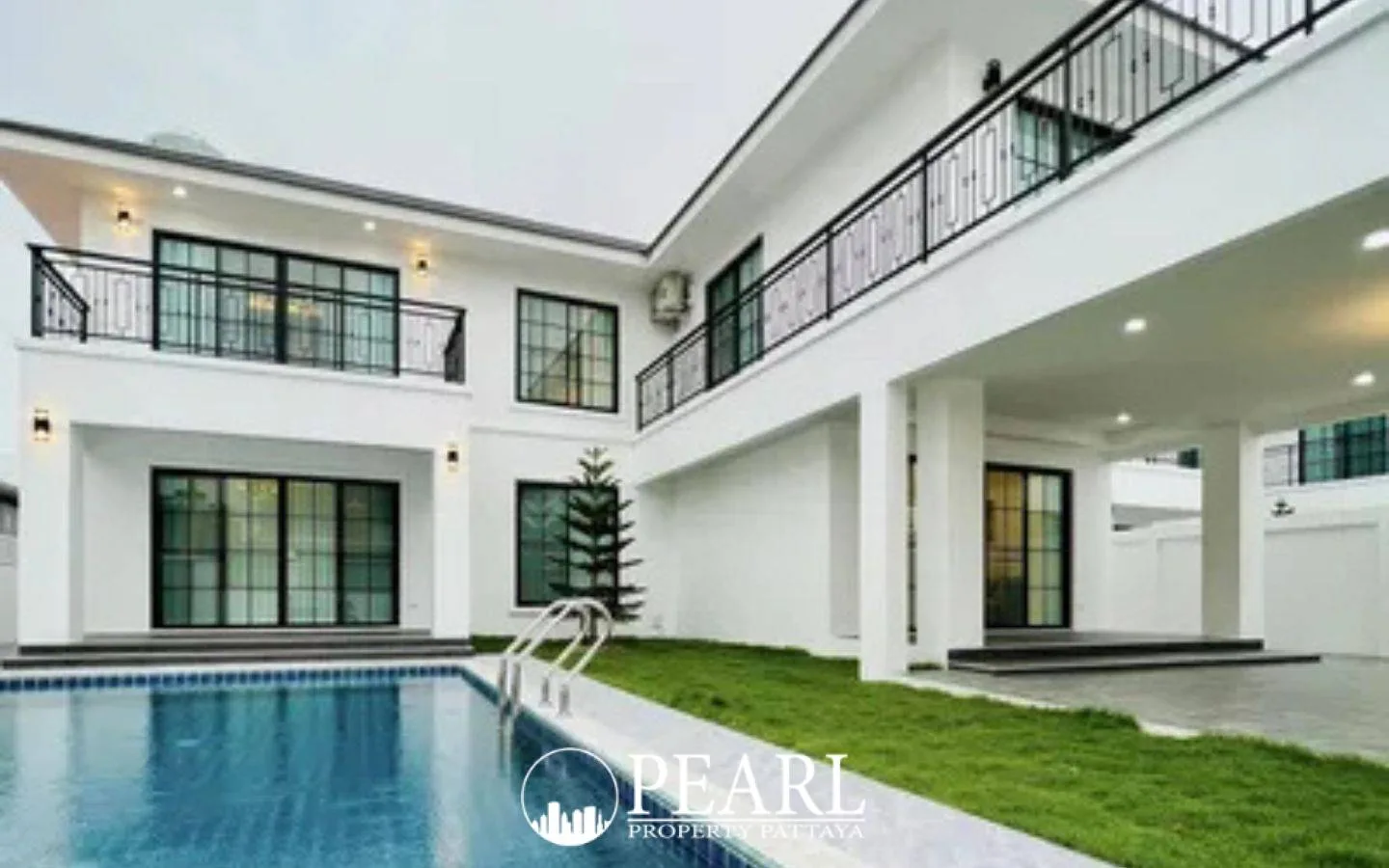 T.W. Wanasin property entrance sign with logo, name in Thai and English, brick accents, and landscaping.