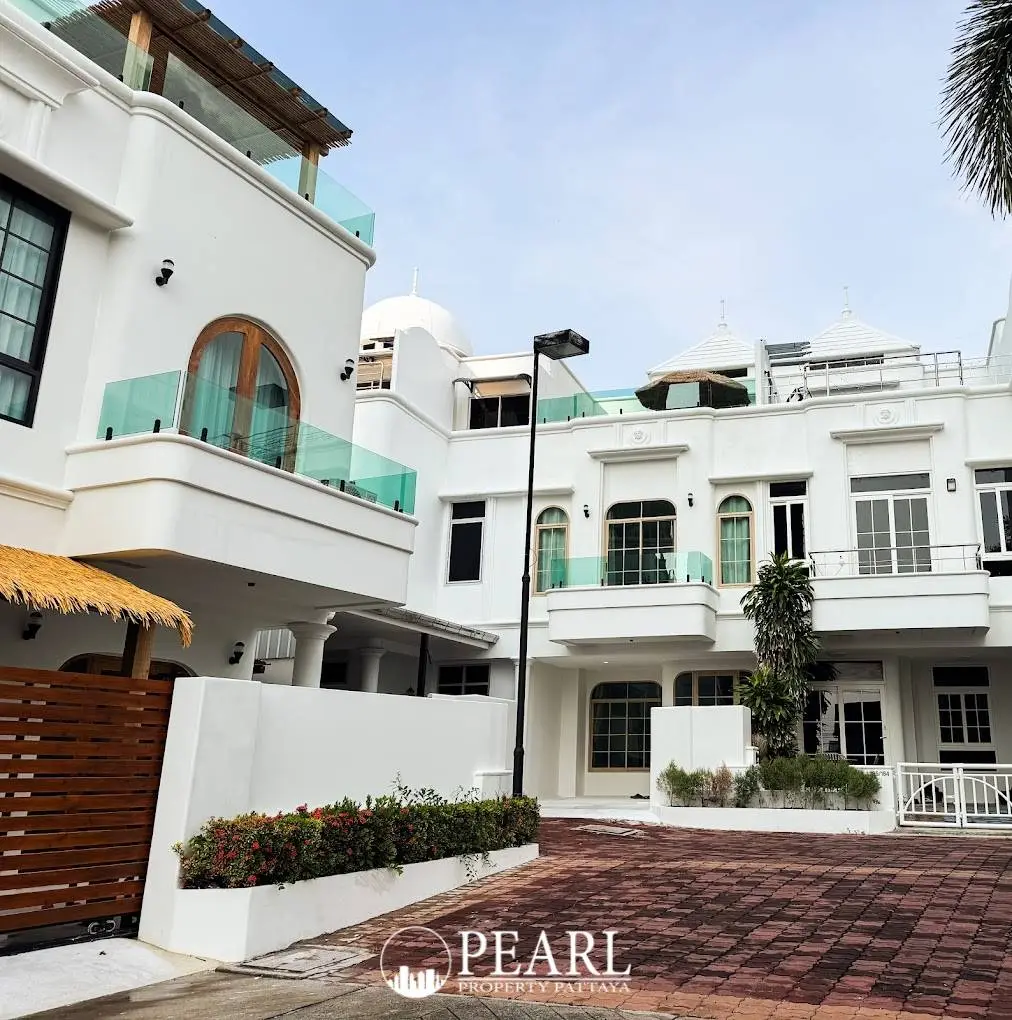 Wongamat Exclusive Place modern white house exterior with glass balconies and a paved driveway.