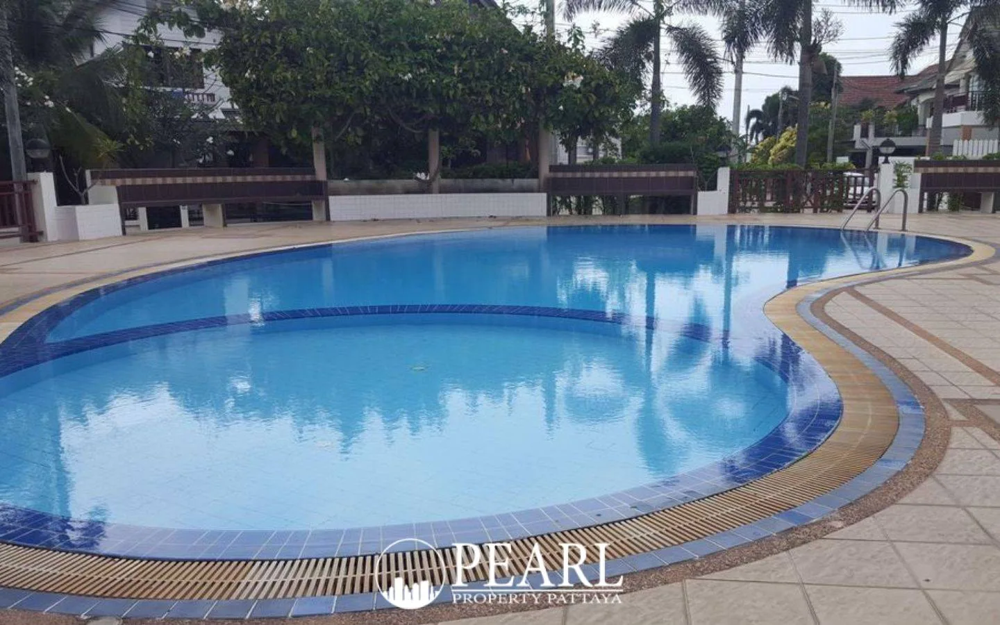 Central Park 4 children's playground with colorful slides, swings, and palm trees on a green lawn.