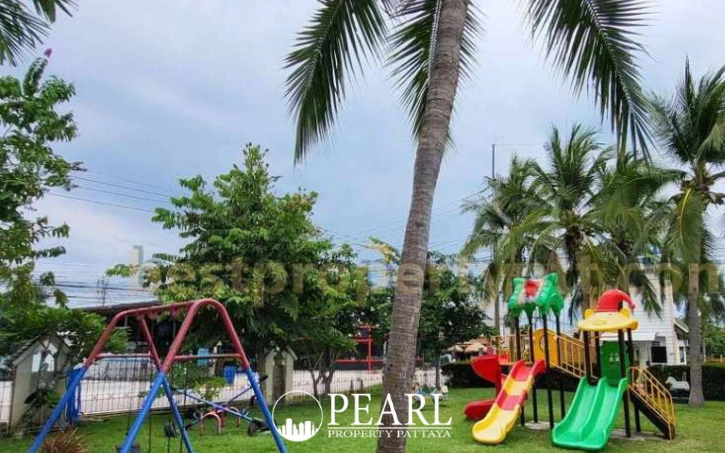 Central Park 4 children's playground with colorful slides, swings, and palm trees on a green lawn.