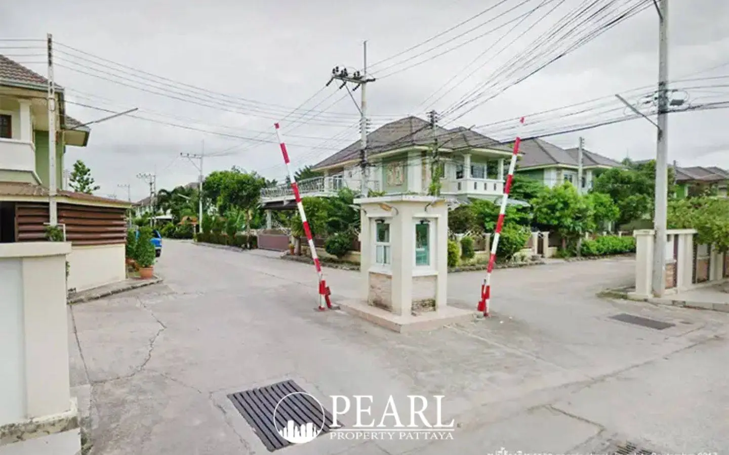 Park Hill Village entrance with security booth, red and white barrier arms, and houses in the background.