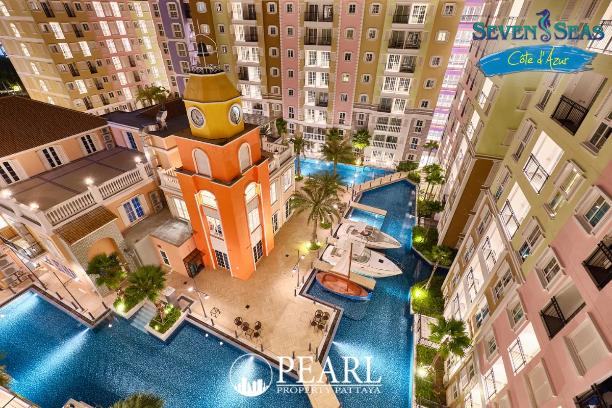 Seven Seas Cote d'Azur: Overhead view of a central clock tower, swimming pools, and residential buildings at night.