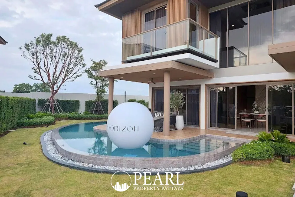 Horizon By Patta large outdoor swimming pool with a white slide, surrounded by green grass and a modern building.