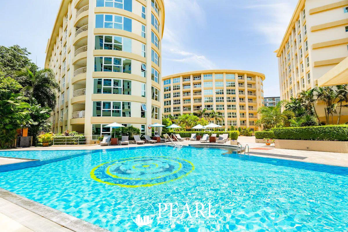 City Garden Pattaya large swimming pool with a circular mosaic, surrounded by apartment buildings and green landscaping.