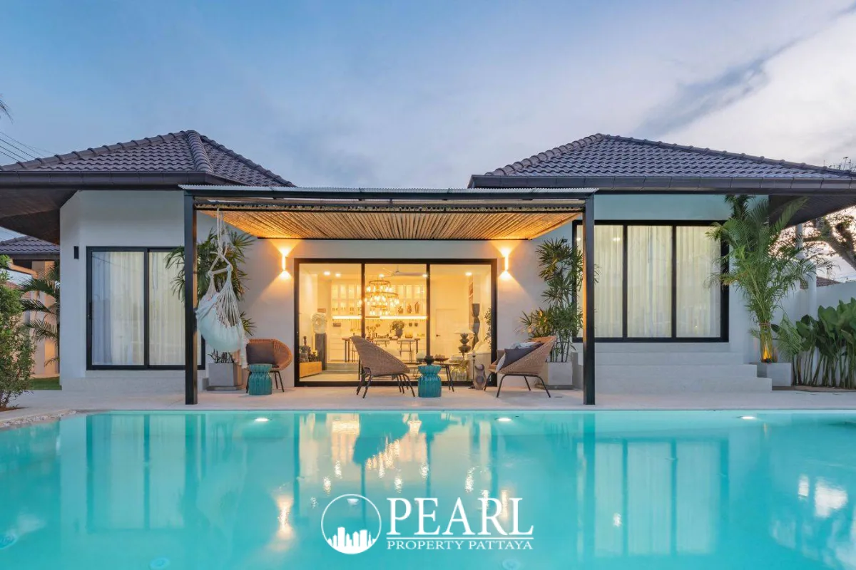 Srisuk Villa modern house exterior with private swimming pool, outdoor seating, and illuminated interior at dusk.