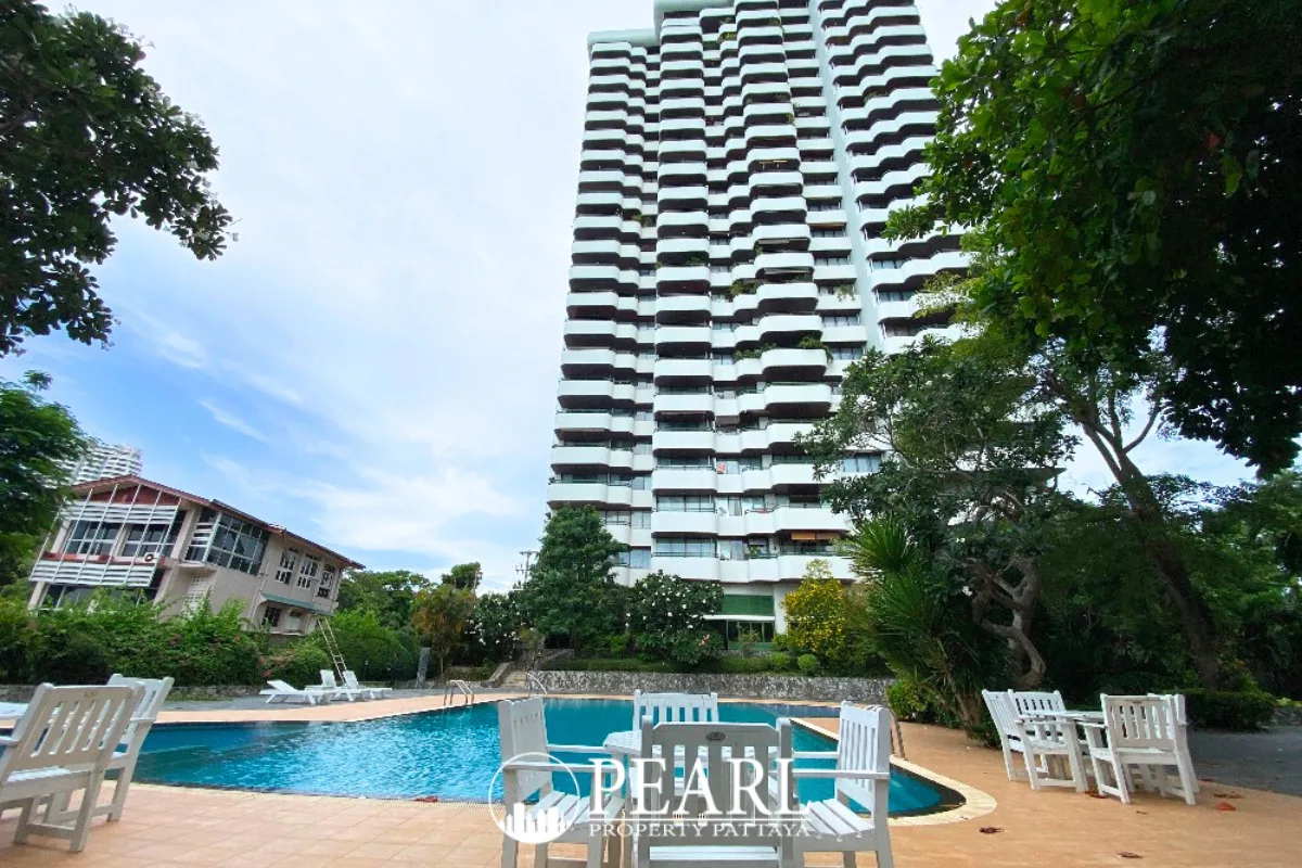 Sunset Heights Condominium: Exterior view of the tall building, a large swimming pool, and outdoor dining furniture.