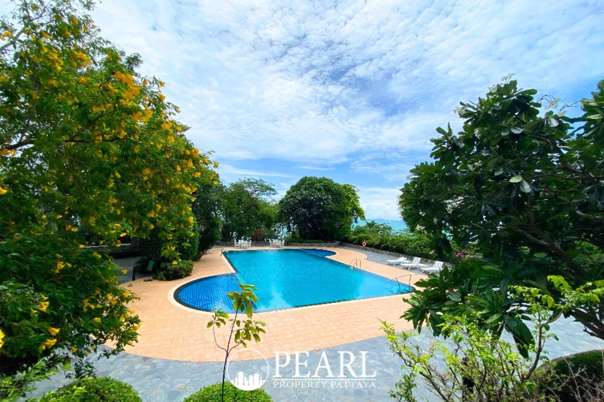 Sunset Heights Condominium: Exterior view of the tall building, a large swimming pool, and outdoor dining furniture.