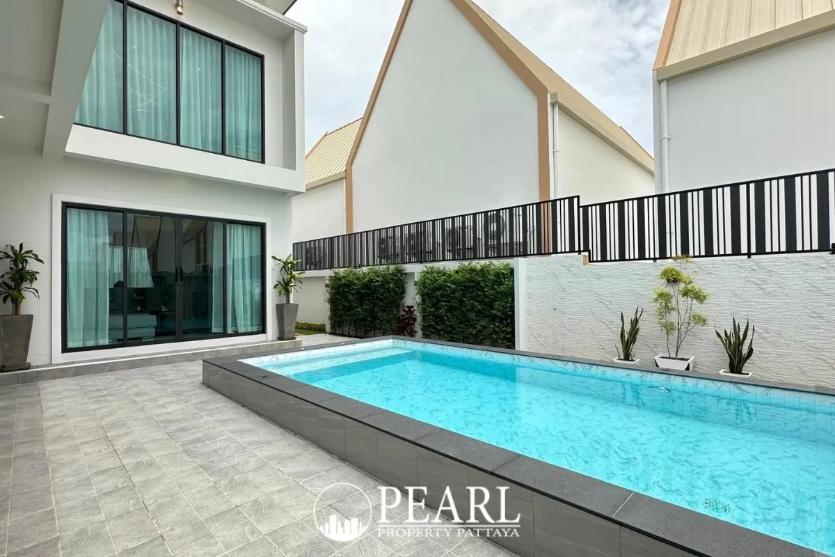 Jin Village modern white house with a private swimming pool, large windows, and an open carport.