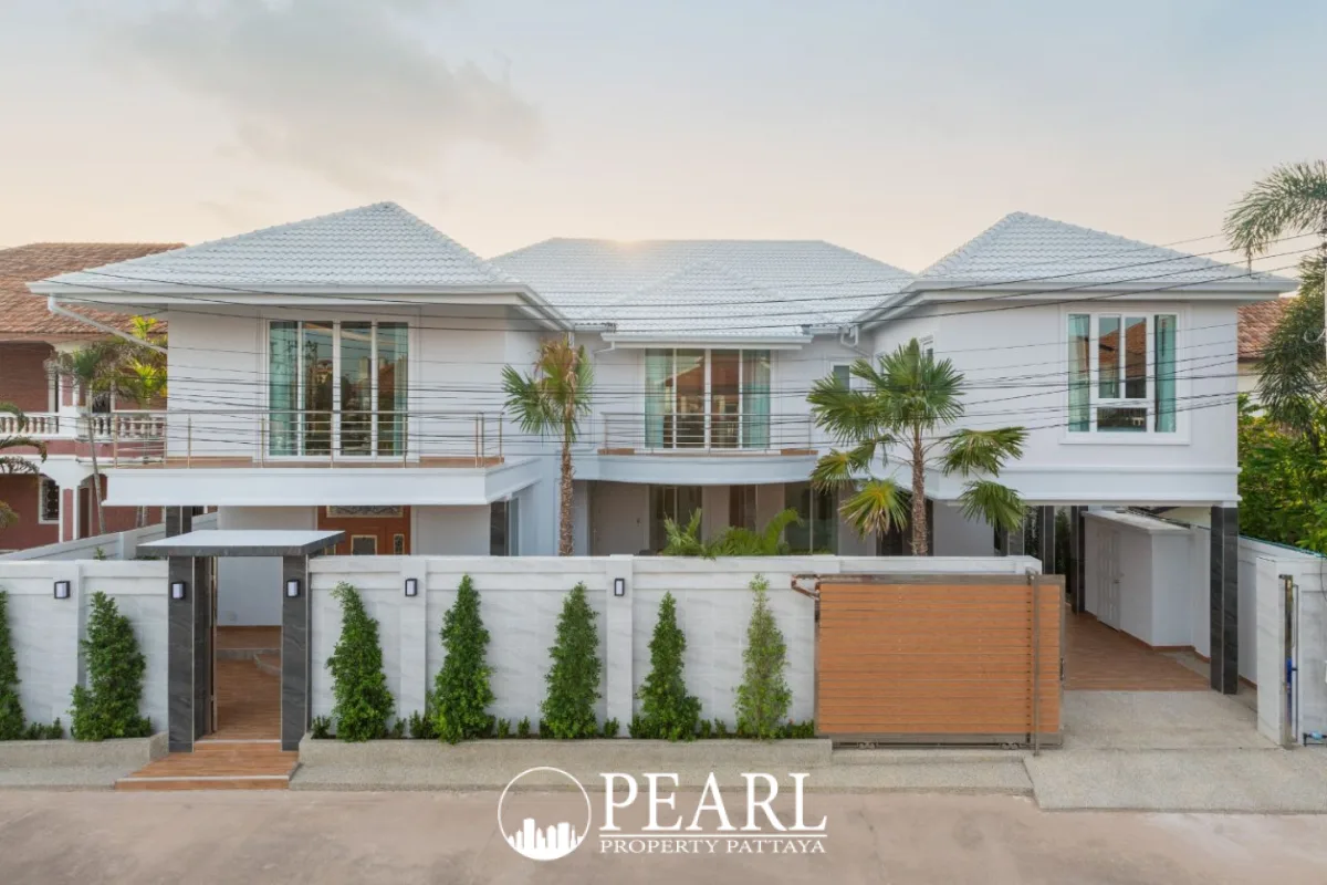 Pattaya Lagoon Village modern white house exterior with gated entrance and driveway under a clear sky.