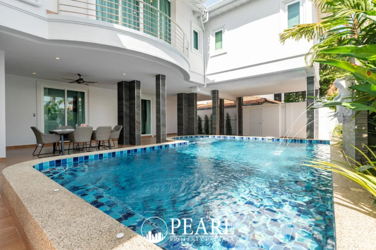 Pattaya Lagoon Village side view of the modern white house with a privacy fence and gated pedestrian entrance.