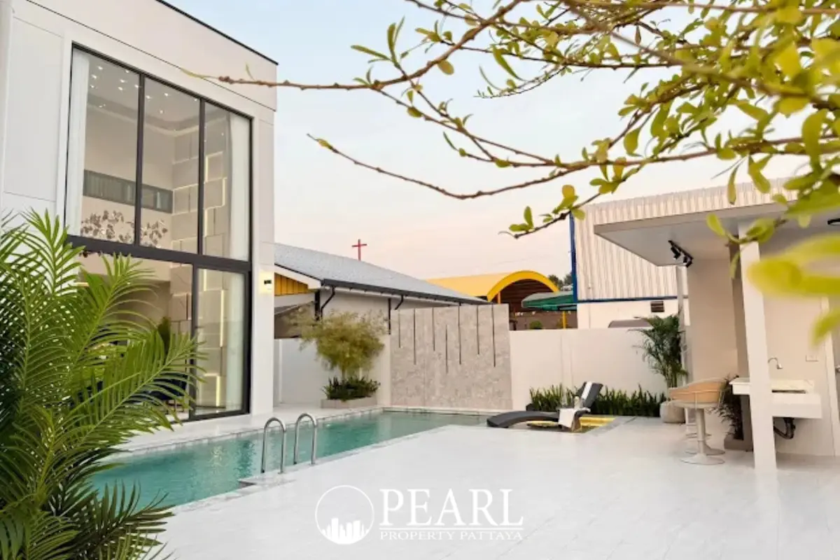 AVANI Pool Villa modern exterior with white and grey facade, carport, and two luxury cars parked in front.