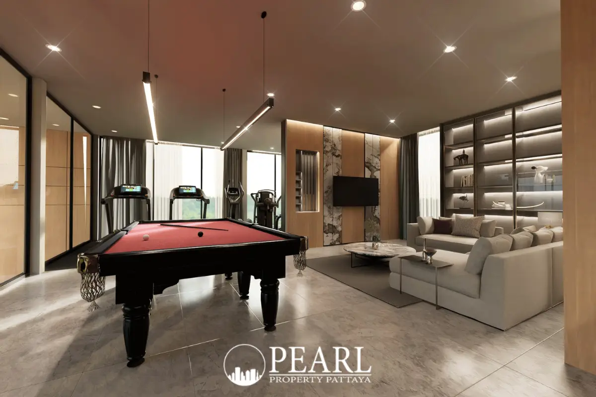 Baan Mae 12 – Onyx Grand Village entertainment room with a red pool table, sofa, and gym equipment.