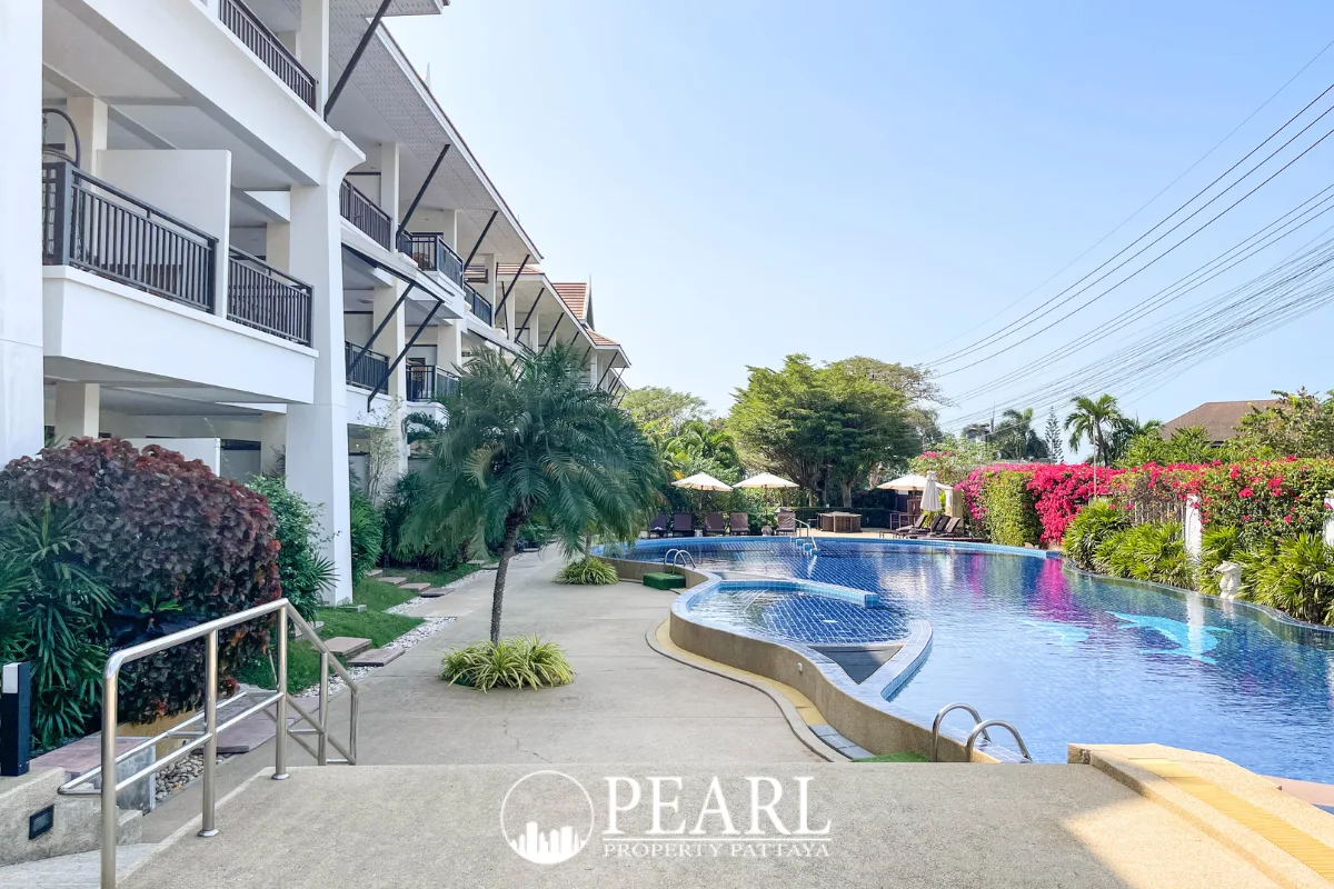 Sunrise Beach Residence outdoor swimming pool with blue mosaic tiles, showing pool entry steps and a white building in the background.