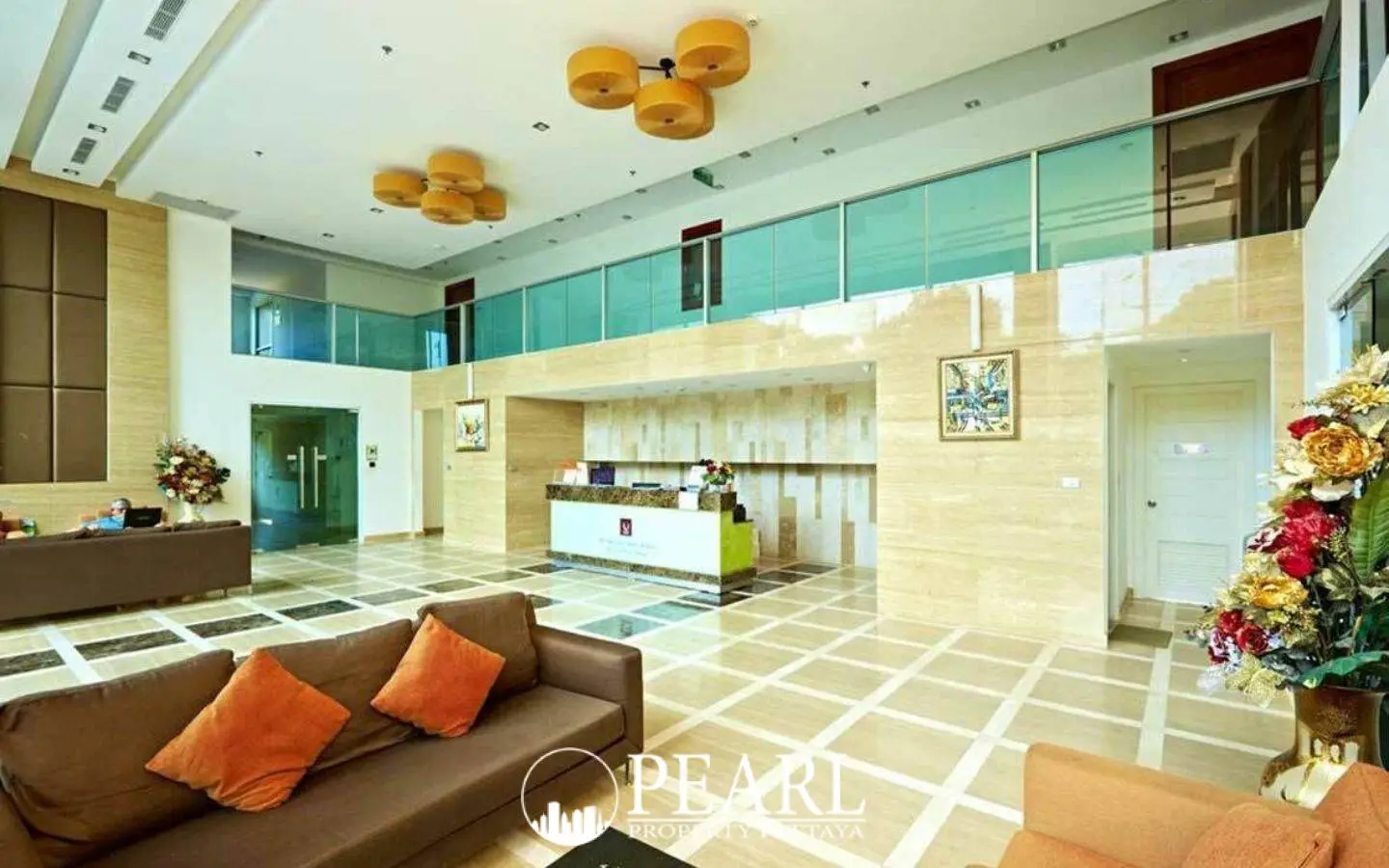 Cosy Beach View spacious and elegant lobby with marble floors, reception desk, brown sofas, and decorative lighting