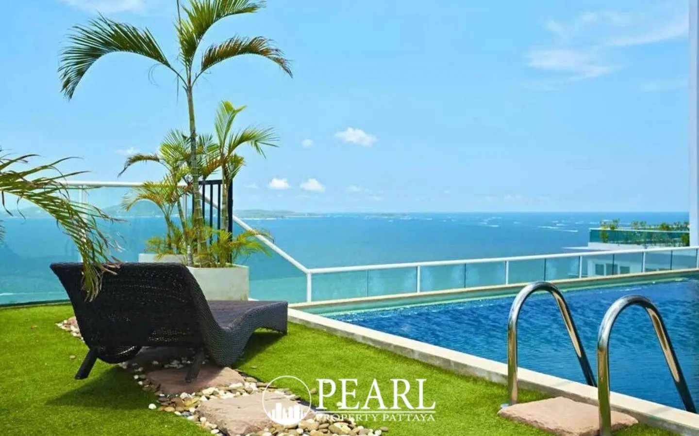 Cosy Beach View rooftop pool with a lounge chair on artificial grass, palm trees, and expansive ocean views