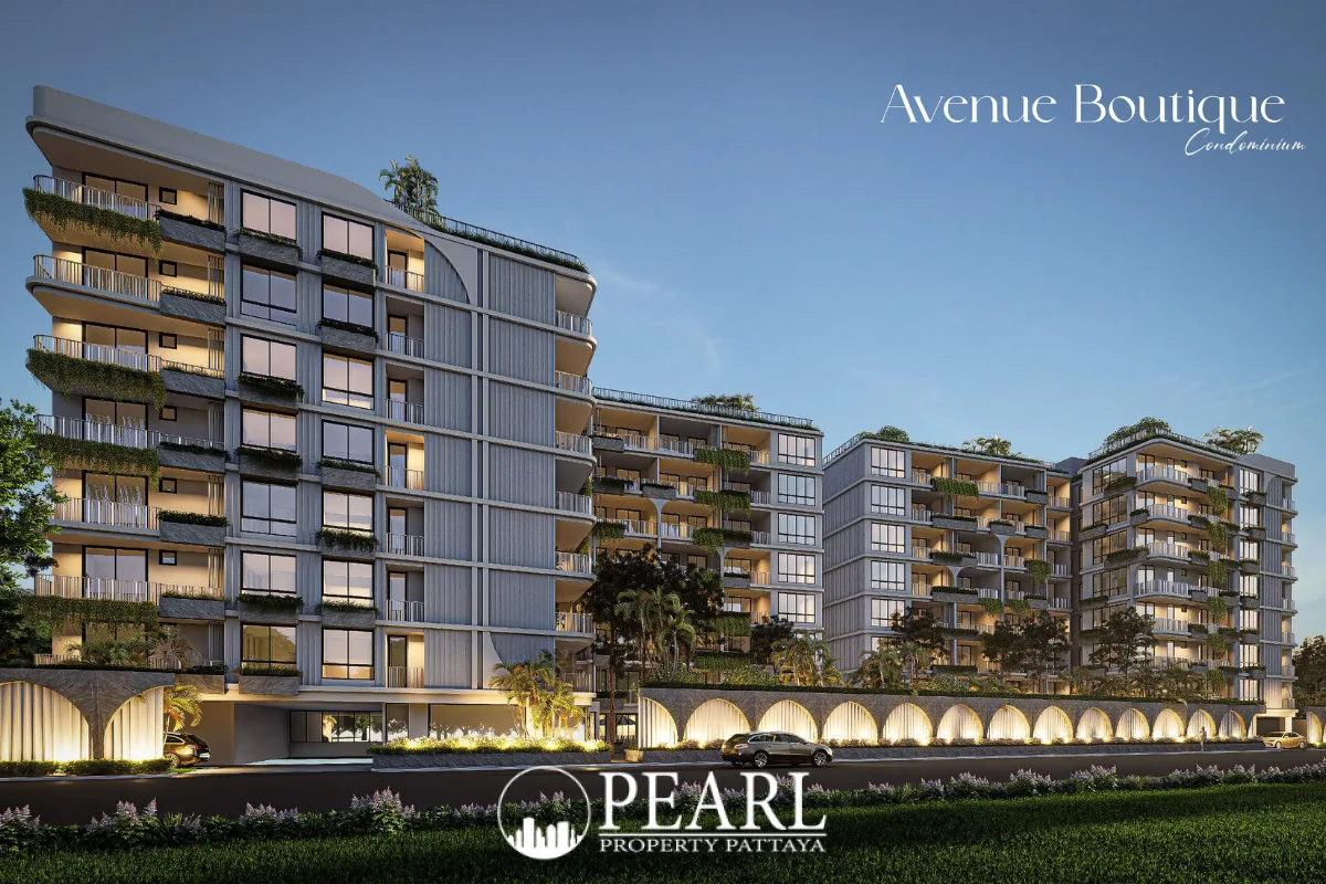 Avenue Boutique Pattaya: Modern condo building exterior at dusk with illuminated facade and lush landscaping.