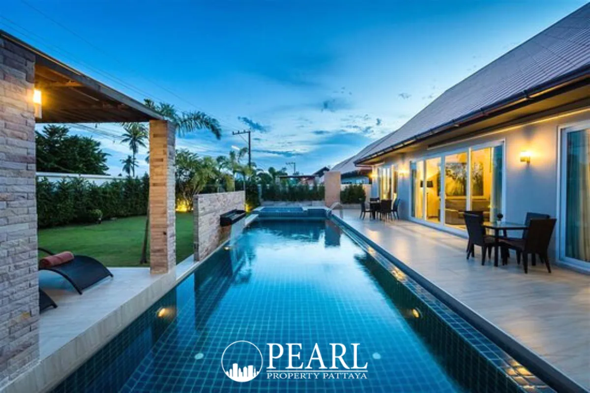 The Ville Jomtien private swimming pool with blue tiles, water feature, and sun loungers.