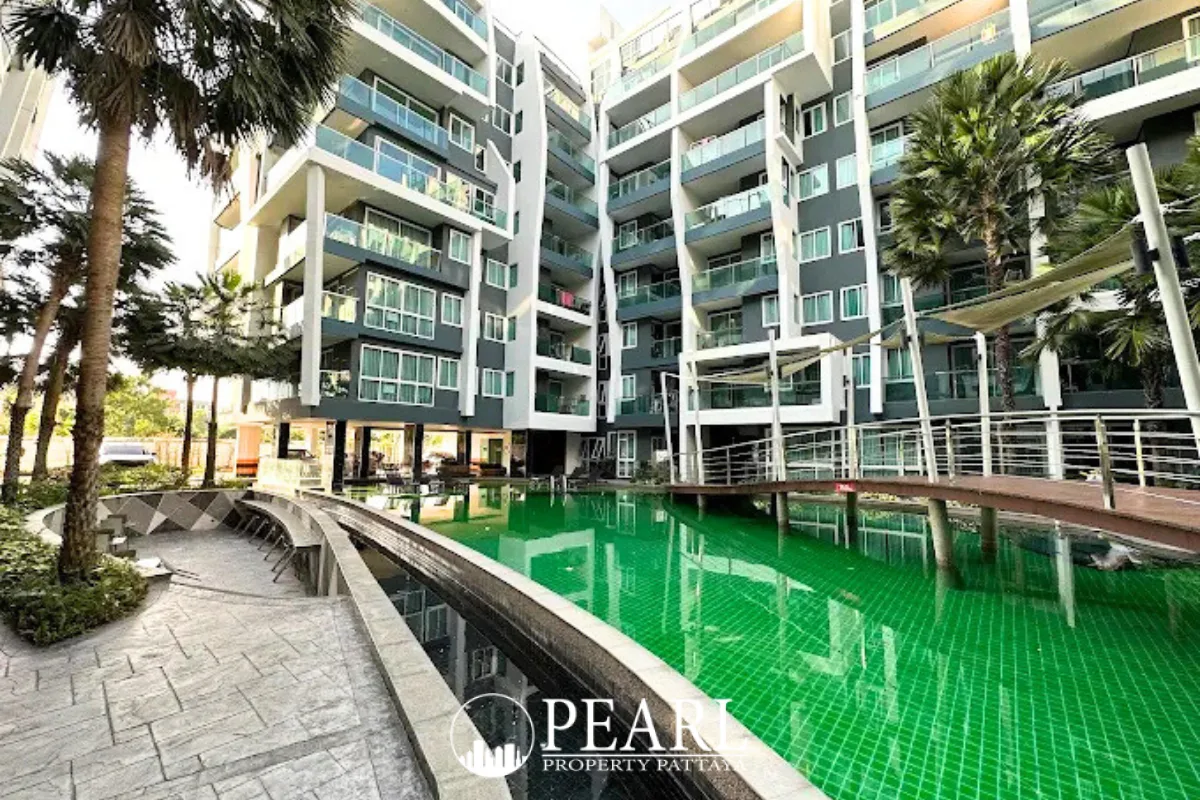 The Feelture Condominium entrance sign with a dark marble-like facade and green lettering under a blue sky.