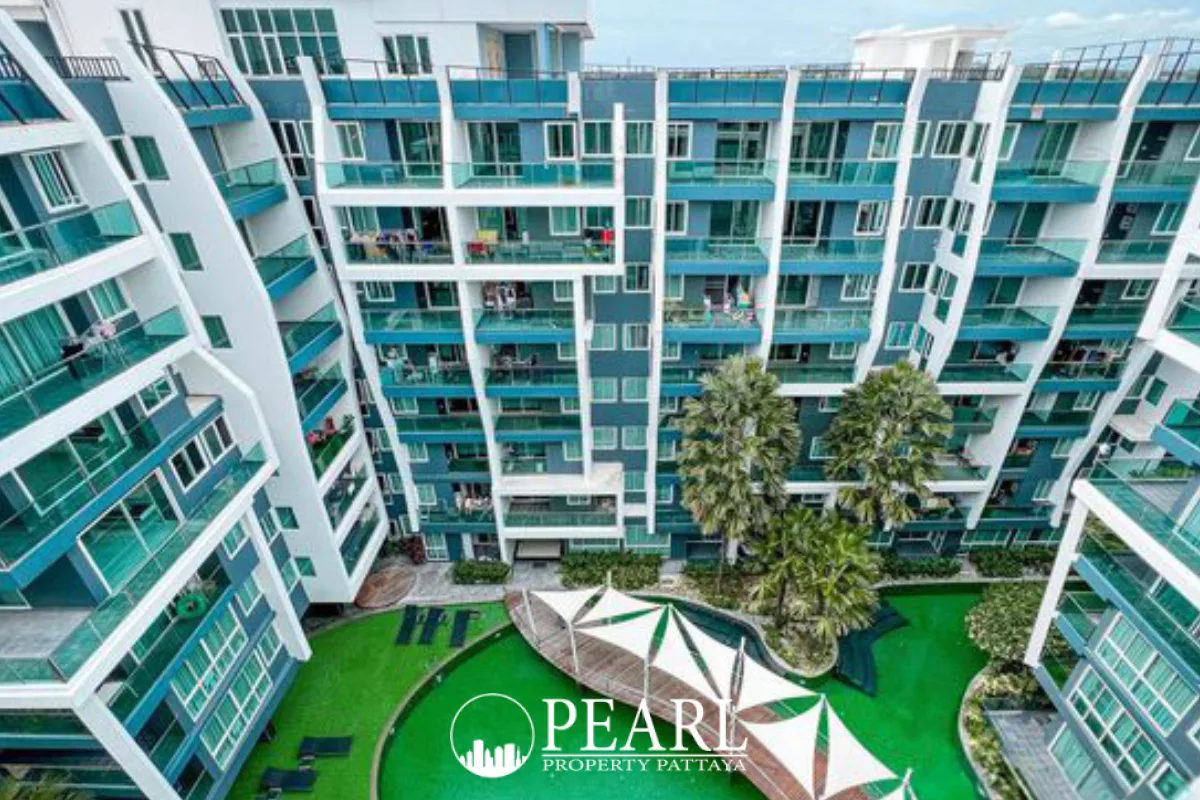 The Feelture Condominium exterior showing the building facade, green swimming pool, and tropical landscaping.