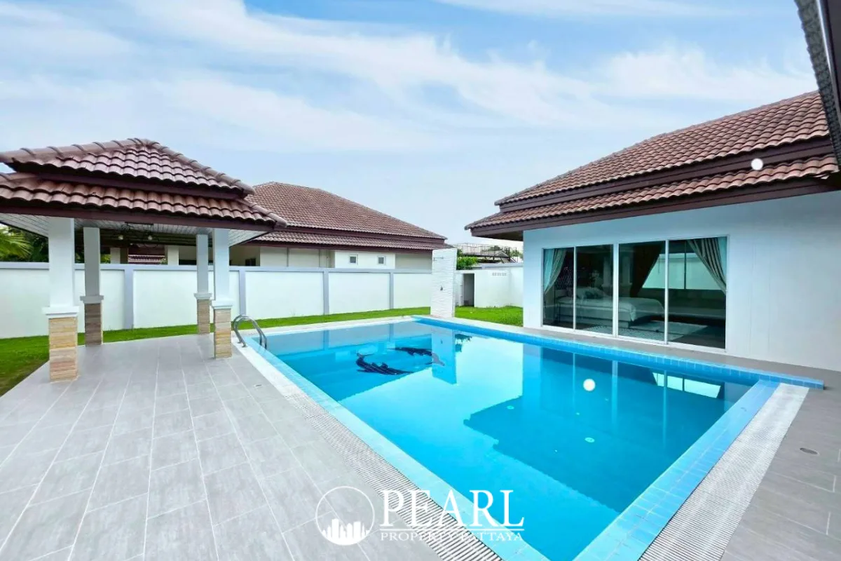 Unique Paradise Resort outdoor swimming pool with a covered patio, tiled deck, and house with glass sliding doors.