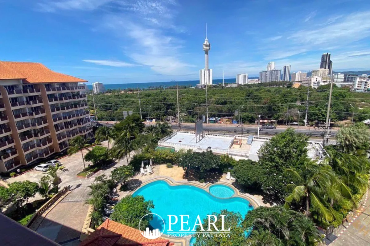 Royal Hill Resort main entrance and large outdoor swimming pool with sun loungers, surrounded by tropical plants.