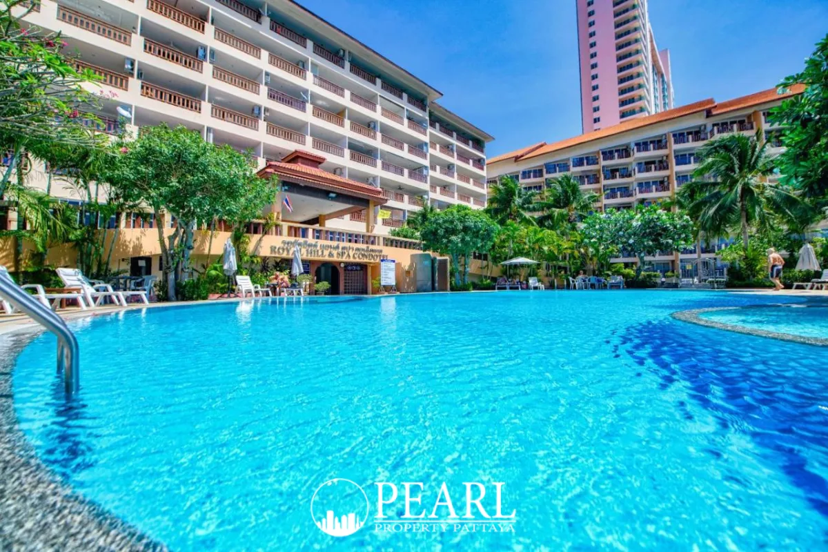 Royal Hill Resort inviting outdoor swimming pool with resort buildings, palm trees, and clear blue water.