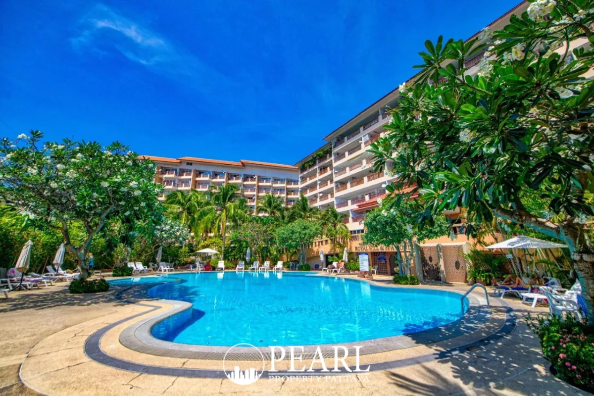 Royal Hill Resort large outdoor swimming pool with lounge chairs and lush tropical landscaping under a blue sky.