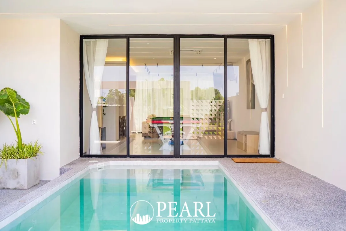 Aura Villa Reserve private plunge pool with glass sliding doors leading to an indoor living area.
