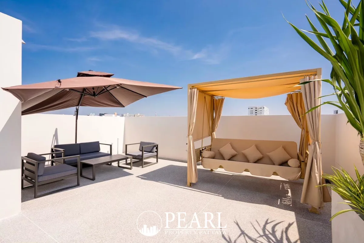 Aura Villa Reserve rooftop terrace with a large umbrella, outdoor seating, and a daybed canopy.