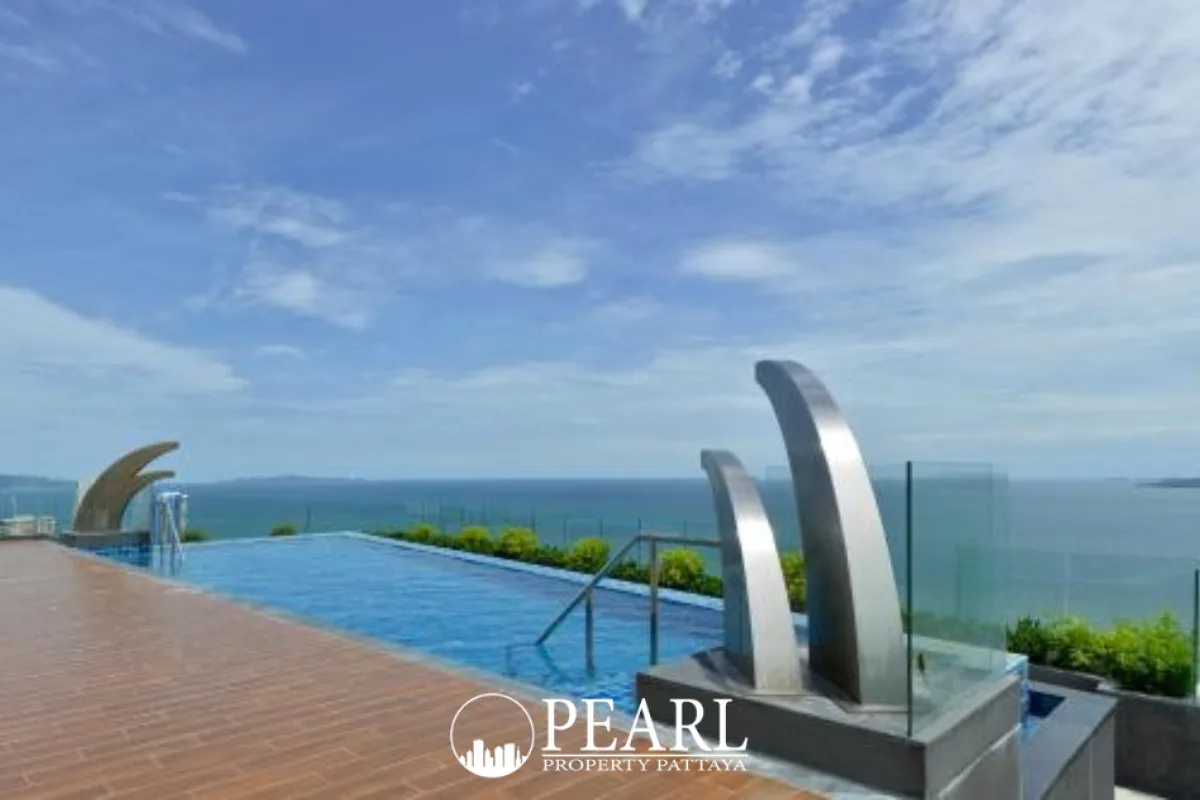 The Peak Towers exterior view from street level, showing the building's facade and a stone wall with its name.