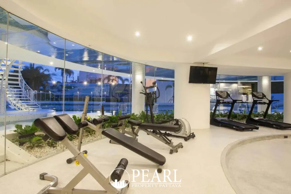 La Royale Beach curved swimming pool directly overlooking the ocean under a clear sky with lounge chairs.