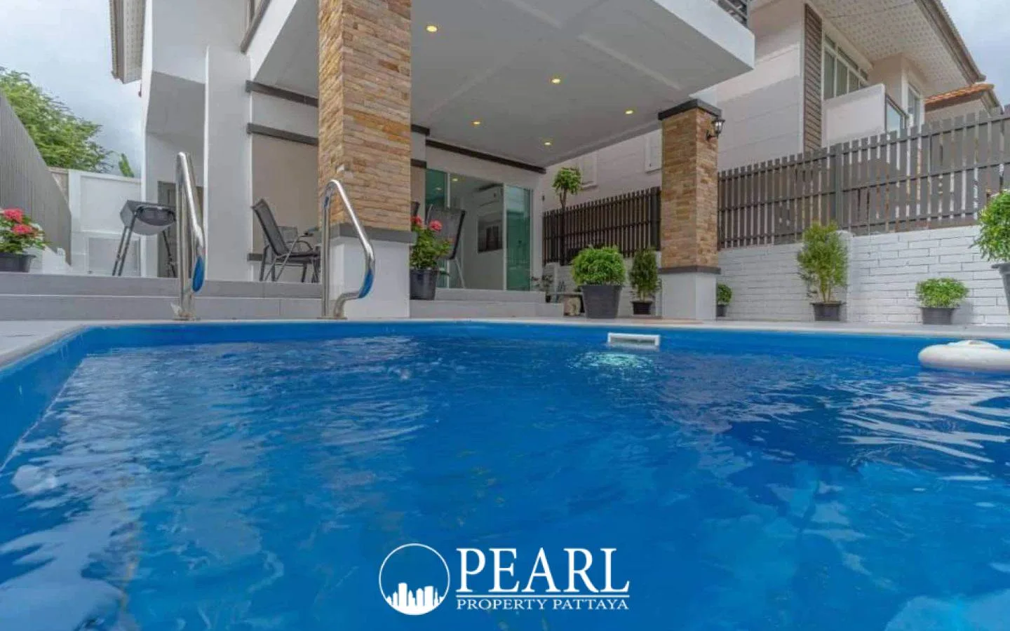 TW. Garden Hill row of modern white houses with black balconies and utility poles under a cloudy sky.