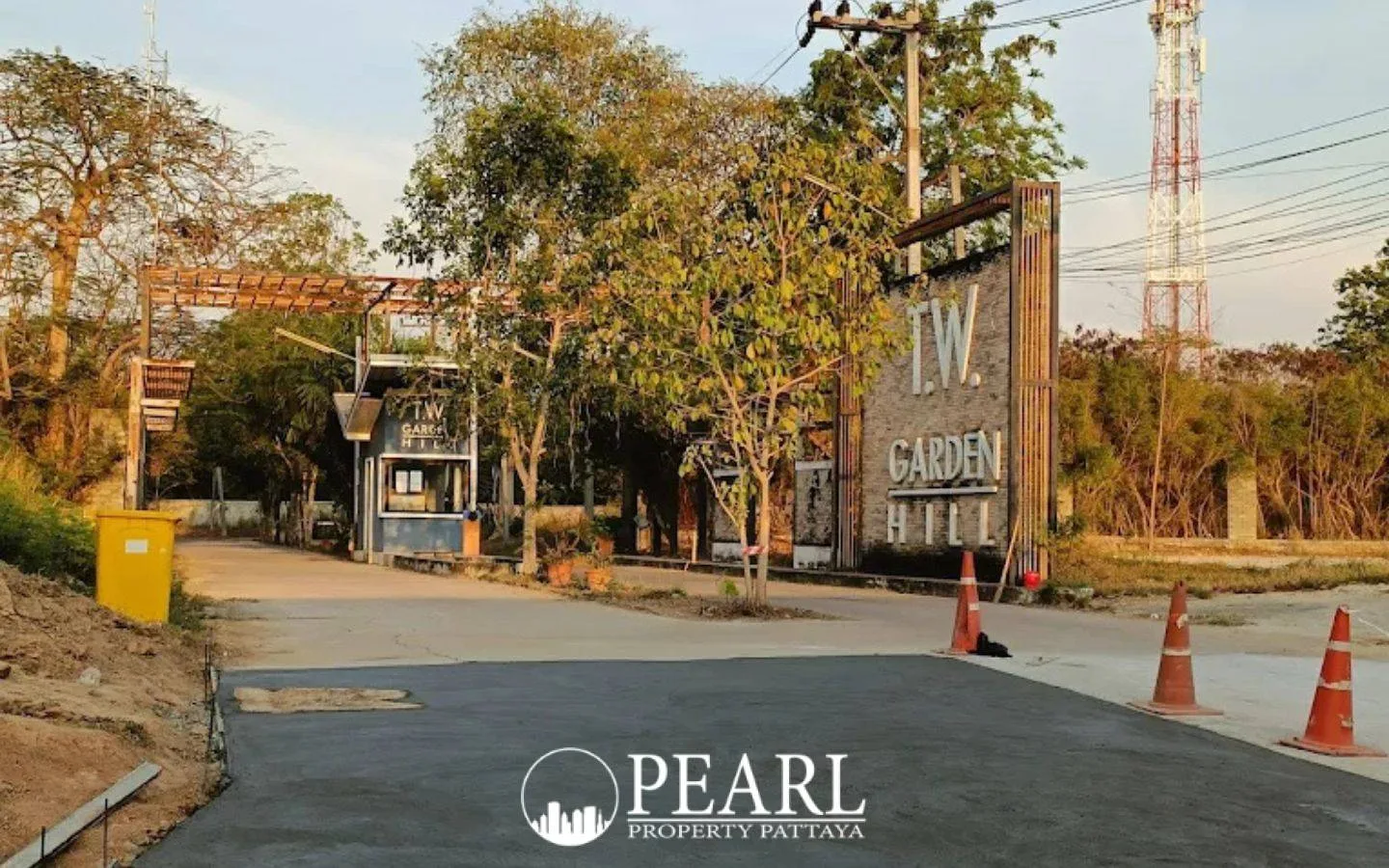 TW. Garden Hill main entrance gate with security booth, large sign, and construction area in Pattaya.