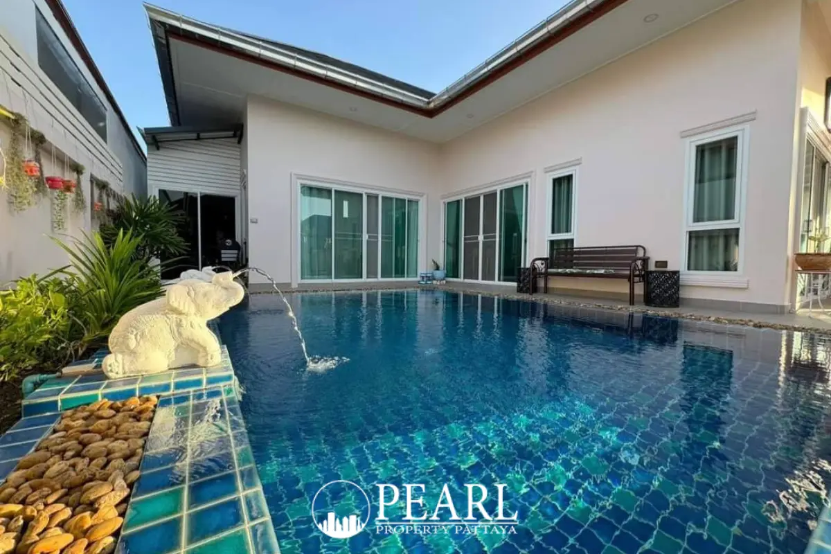 Baan Dusit Garden 6 main entrance gate with security booth, signage, and palm trees under a blue sky.