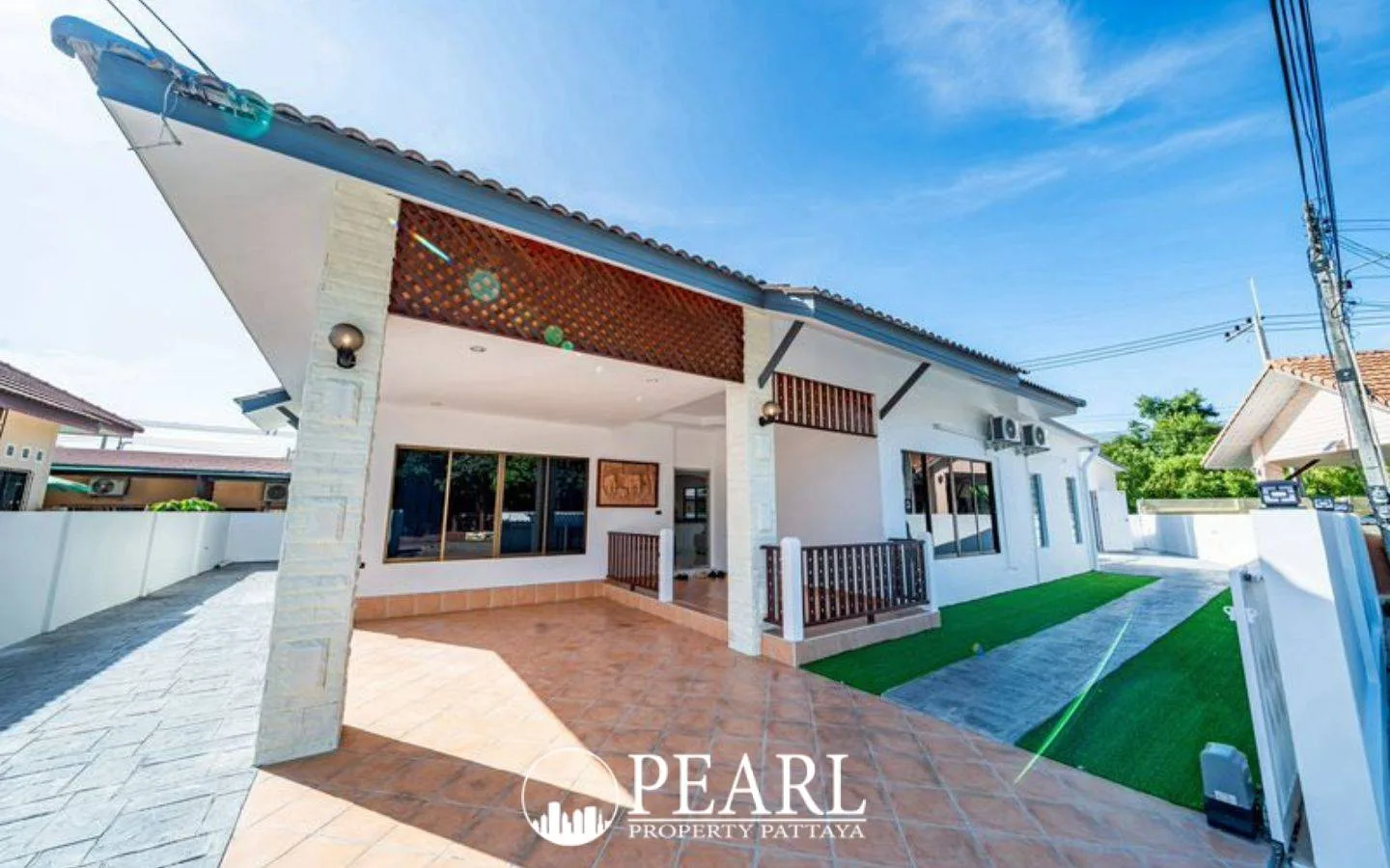 Pattaya Paradise Village 2 house exterior with covered carport, tiled driveway, and artificial turf.