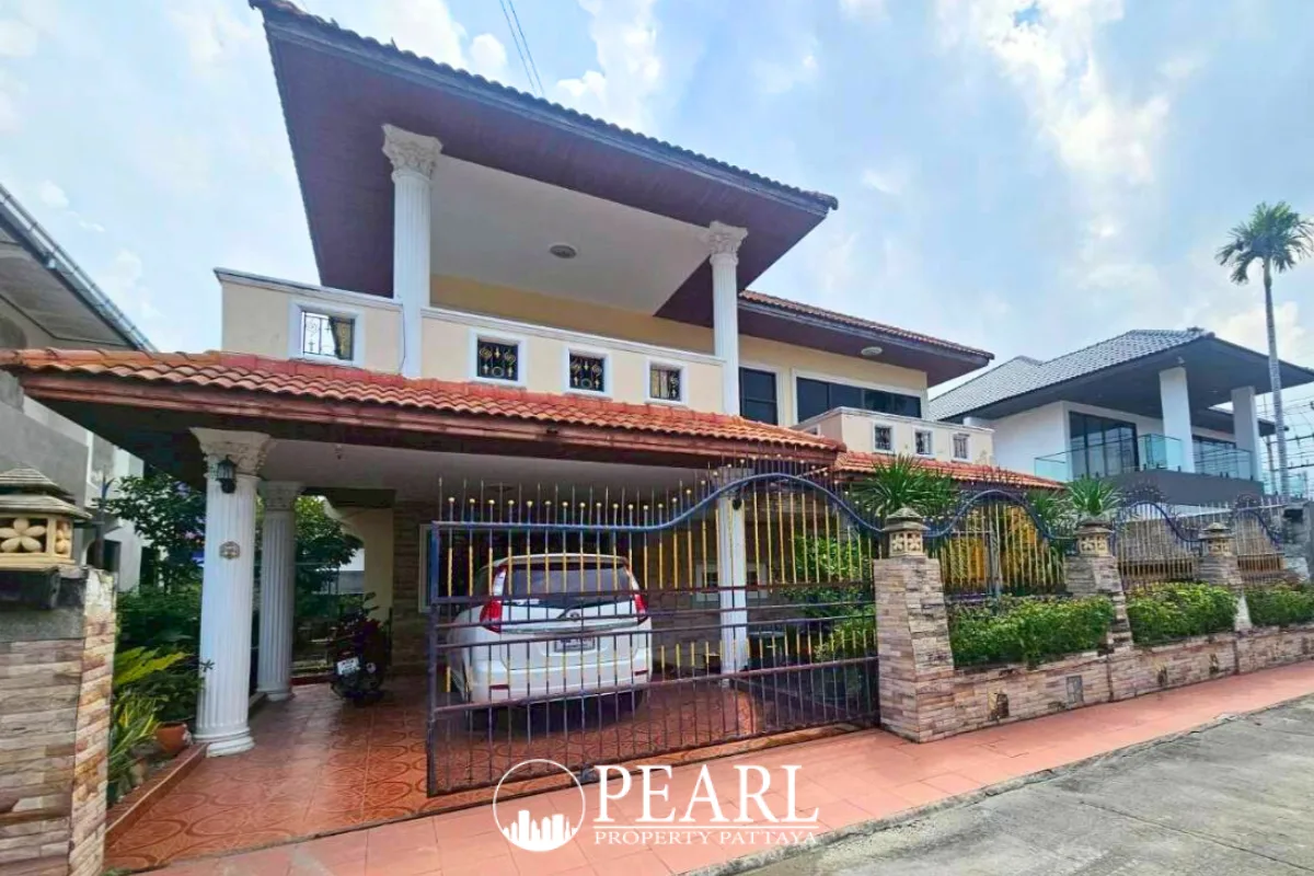 Eakmongkol Village Chaiyapruek 2 large cream house with covered carport, ornate gate, and tiled roof.