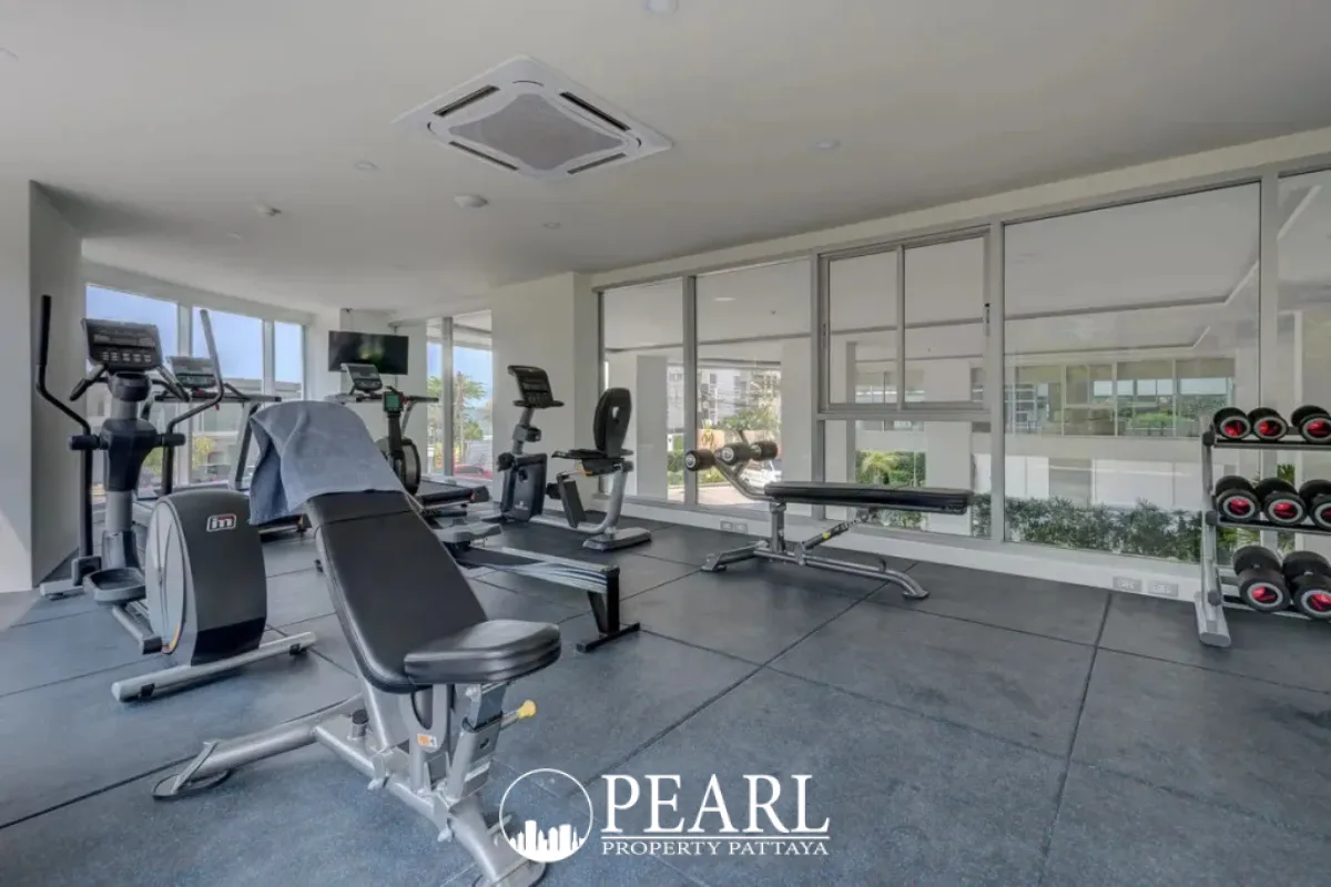 Sands Condominium modern fitness center with various exercise machines, weights, and large windows.