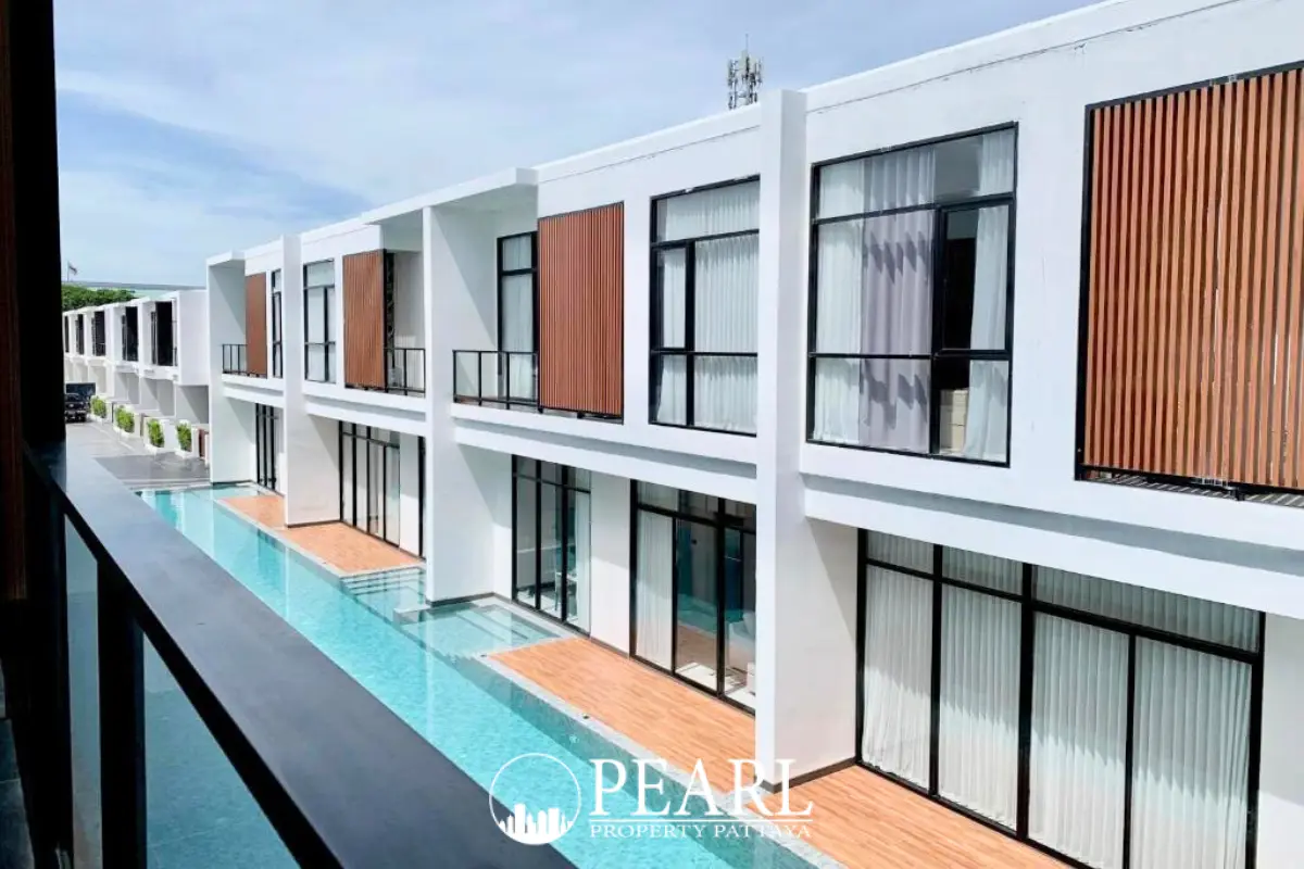 The Rich Garden modern townhouses with private plunge pools and wooden decks under a clear sky.